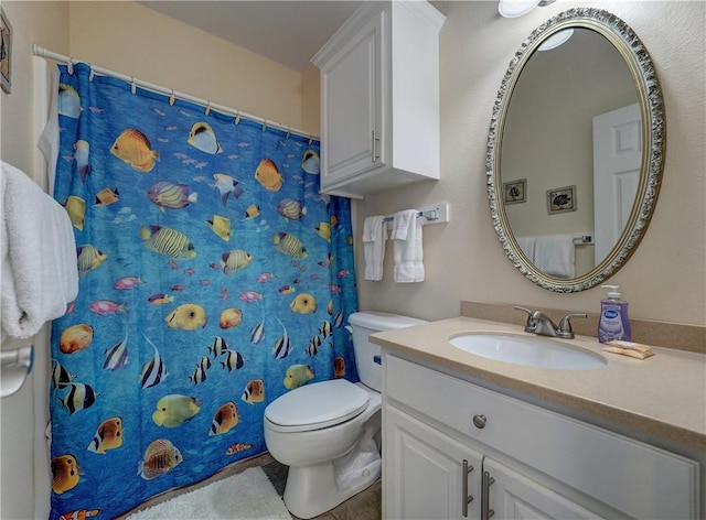 bathroom featuring toilet, vanity, a shower with shower curtain, and tile patterned flooring