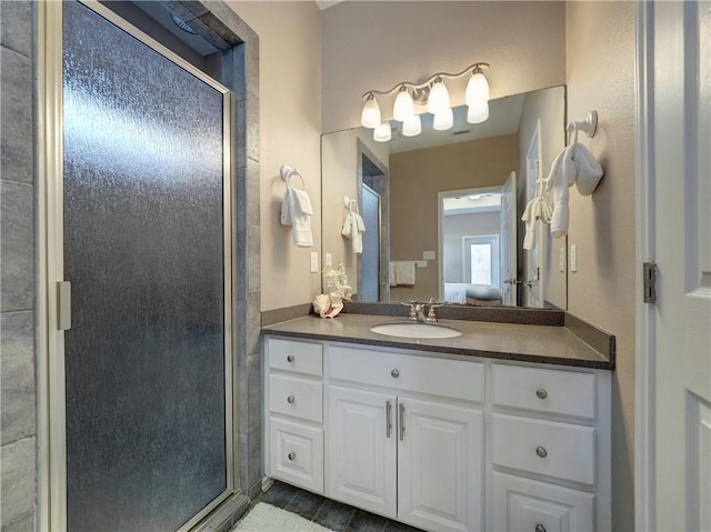 bathroom with a shower with shower door and vanity