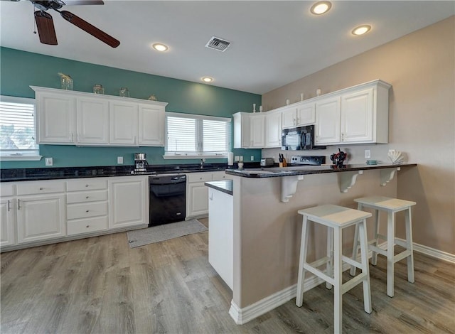 kitchen with white cabinetry, light hardwood / wood-style floors, and black appliances