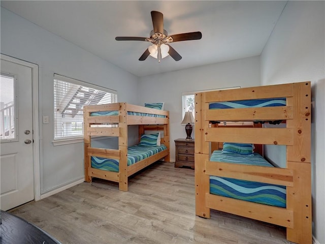 bedroom featuring ceiling fan, multiple windows, and hardwood / wood-style flooring