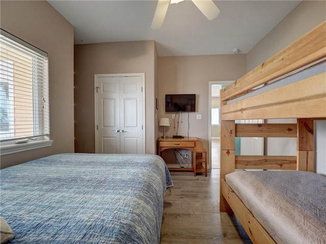 bedroom with ceiling fan, wood-type flooring, and a closet