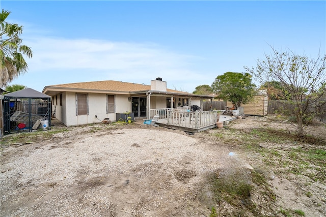 rear view of property with a shed, a wooden deck, and a gazebo