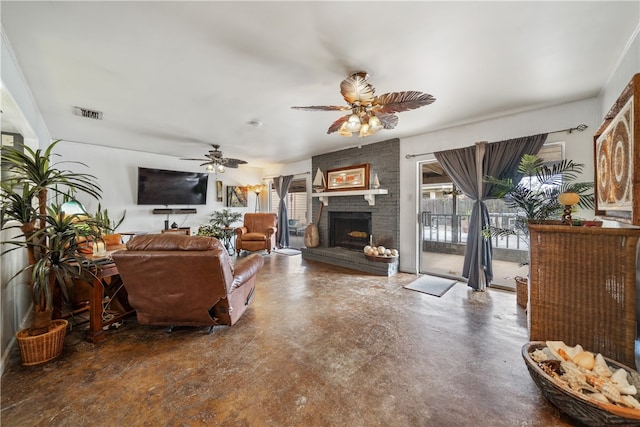 living room with ceiling fan, a brick fireplace, and concrete floors