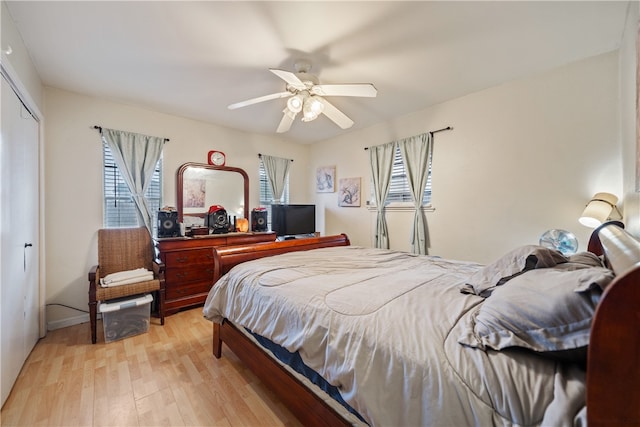 bedroom with ceiling fan, light hardwood / wood-style floors, and a closet