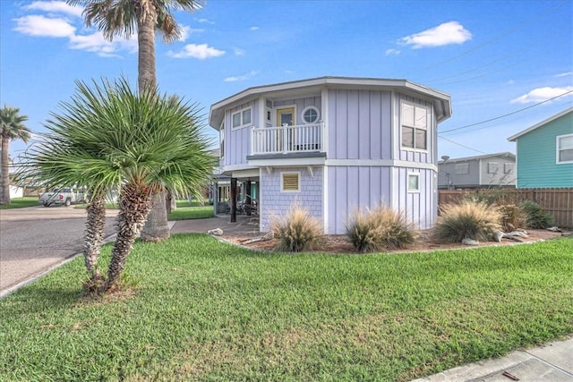 view of front of home featuring a balcony and a front lawn