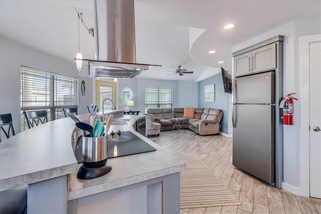 kitchen featuring stainless steel fridge, gray cabinets, plenty of natural light, and ceiling fan