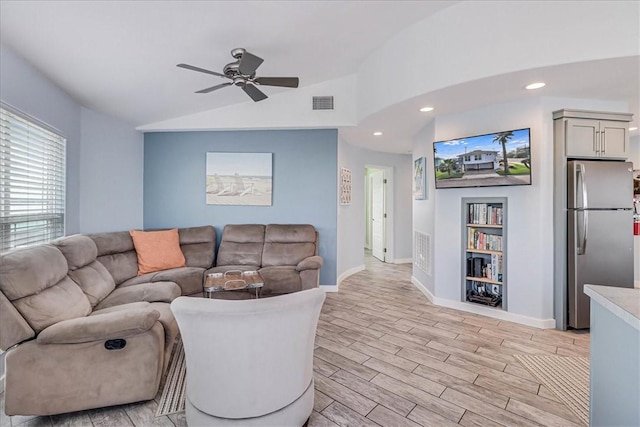 living room with ceiling fan, vaulted ceiling, and light wood-type flooring