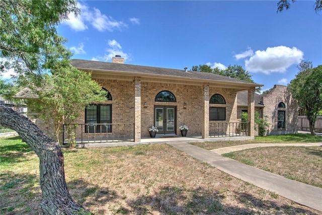 4102 Castle Valley Dr, Corpus Christi, TX 78410 - split foyer home with french doors, brick siding, a chimney, a porch, and a front yard