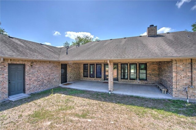 4102 Castle Valley Dr, Corpus Christi, TX 78410 - rear view of property featuring brick siding, a shingled roof, a chimney, and a patio area