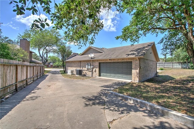 4102 Castle Valley Dr, Corpus Christi, TX 78410 - view of side of property with central AC unit, brick siding, a garage, and driveway