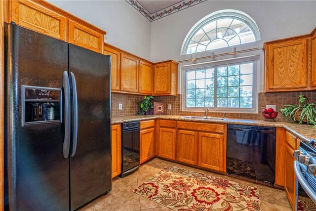 4102 Castle Valley Dr, Corpus Christi, TX 78410 - kitchen featuring black appliances, a sink, brown cabinetry, and backsplash