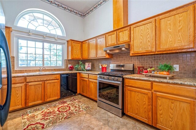 4102 Castle Valley Dr, Corpus Christi, TX 78410 - kitchen featuring stainless steel gas stove, black dishwasher, under cabinet range hood, a sink, and freestanding refrigerator