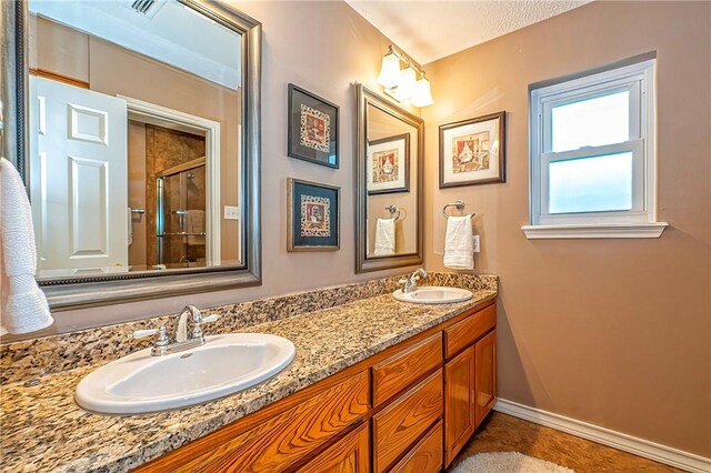4102 Castle Valley Dr, Corpus Christi, TX 78410 - bathroom featuring double vanity, a shower with door, and baseboards