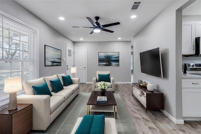 living room with ceiling fan and light hardwood / wood-style flooring