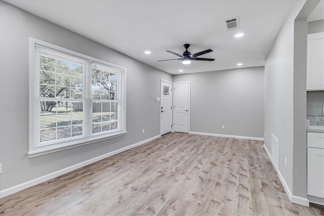 spare room with light wood-type flooring and ceiling fan