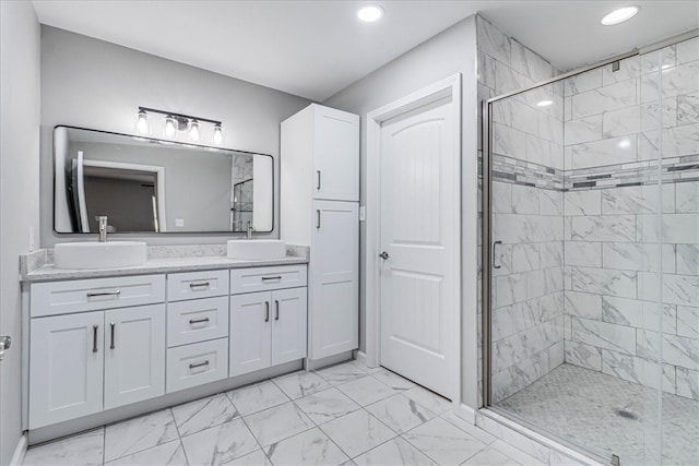 bathroom with a shower with shower door and vanity