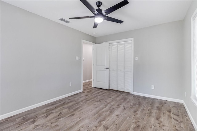 unfurnished bedroom featuring ceiling fan, a closet, and light hardwood / wood-style flooring