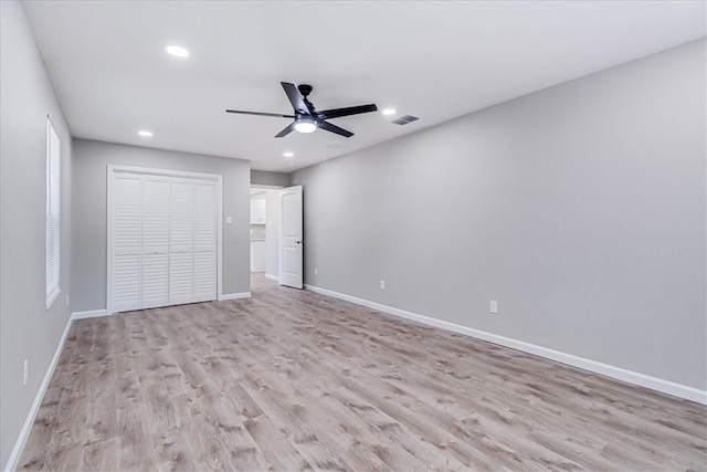 unfurnished bedroom with ceiling fan, a closet, and light wood-type flooring