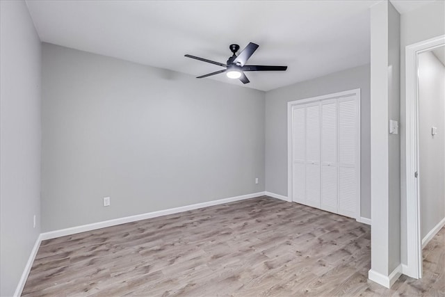 unfurnished bedroom with light wood-type flooring, ceiling fan, and a closet