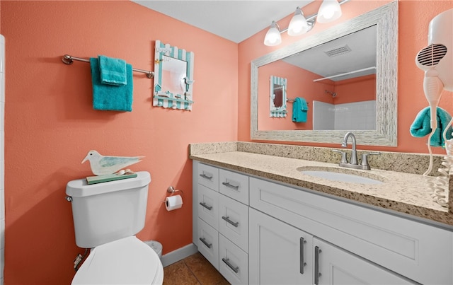 bathroom with walk in shower, vanity, toilet, and tile patterned flooring