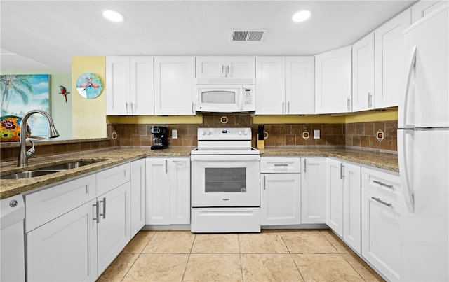 kitchen with white cabinetry, sink, white appliances, and stone countertops