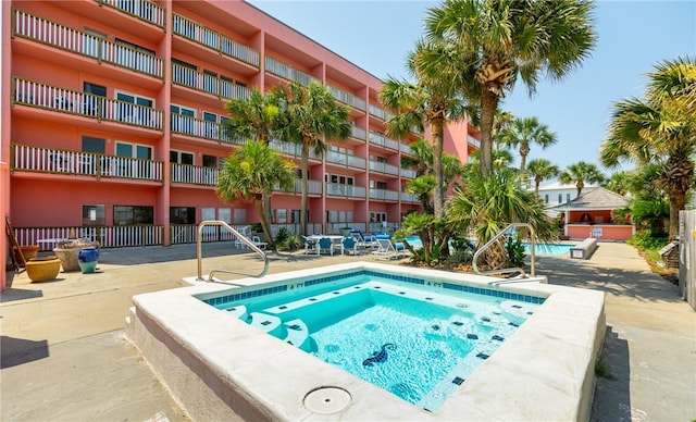 view of pool featuring a hot tub and a patio area