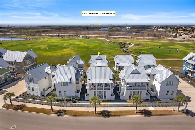 bird's eye view with golf course view, a water view, and a residential view