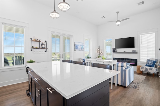 kitchen with plenty of natural light, visible vents, wood finished floors, and a center island