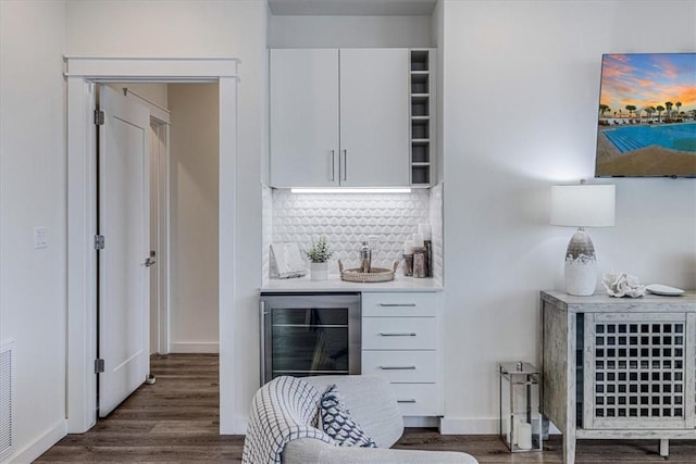 bar featuring wine cooler, backsplash, dark hardwood / wood-style flooring, and white cabinets