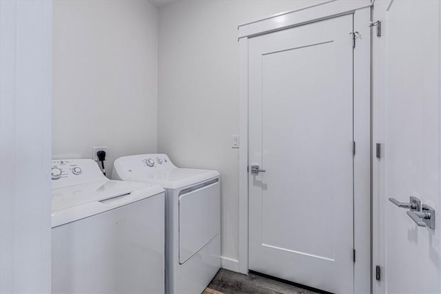 washroom with hardwood / wood-style flooring and washing machine and clothes dryer