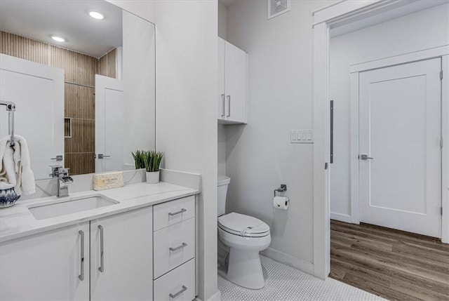 bathroom with vanity, toilet, and wood-type flooring