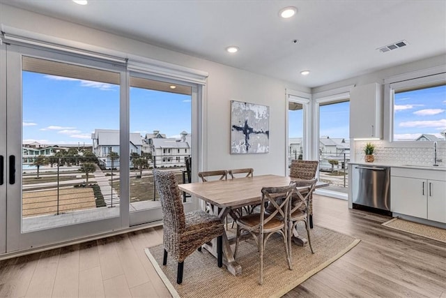 dining room with sink, hardwood / wood-style floors, and a wealth of natural light