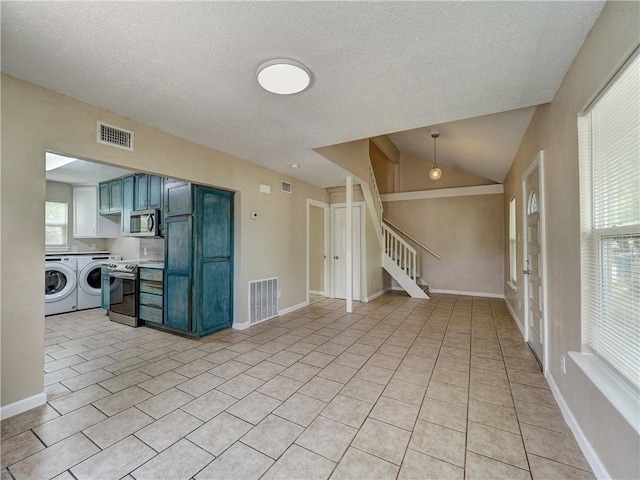 2746 Beaumont Ave, Ingleside, TX 78362 - unfurnished living room with independent washer and dryer, stairs, a textured ceiling, light tile patterned flooring, and baseboards