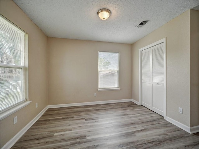 2746 Beaumont Ave, Ingleside, TX 78362 - unfurnished bedroom featuring a closet, a textured ceiling, wood finished floors, and baseboards
