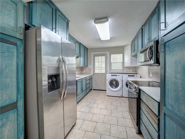 2746 Beaumont Ave, Ingleside, TX 78362 - kitchen with stainless steel appliances, washing machine and dryer, a textured ceiling, light countertops, and light tile patterned floors