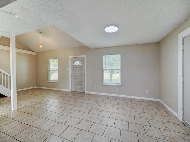 2746 Beaumont Ave, Ingleside, TX 78362 - entrance foyer featuring healthy amount of natural light, a textured ceiling, light tile patterned floors, stairs, and baseboards