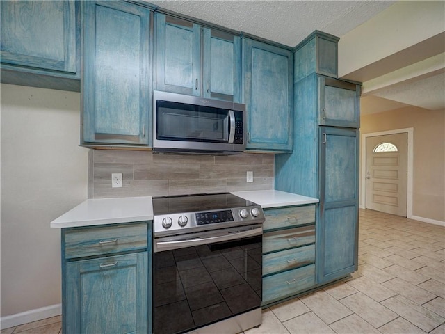 2746 Beaumont Ave, Ingleside, TX 78362 - kitchen with appliances with stainless steel finishes, tasteful backsplash, light countertops, baseboards, and a textured ceiling