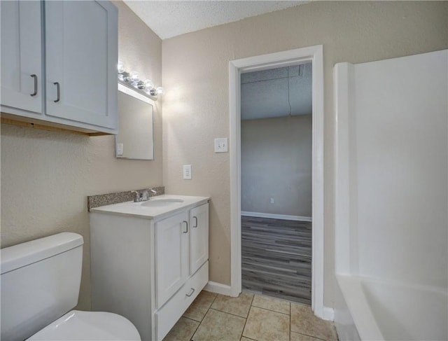 2746 Beaumont Ave, Ingleside, TX 78362 - bathroom with toilet, tile patterned flooring, vanity, baseboards, and a textured ceiling