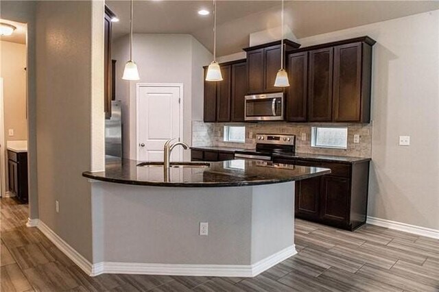 1020 Pasadena St, Portland, TX 78374 - kitchen featuring appliances with stainless steel finishes, dark brown cabinets, baseboards, decorative backsplash, and recessed lighting