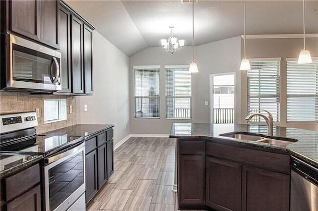 1020 Pasadena St, Portland, TX 78374 - kitchen featuring appliances with stainless steel finishes, a sink, dark stone counters, dark brown cabinetry, and vaulted ceiling