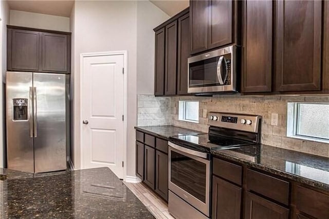 1020 Pasadena St, Portland, TX 78374 - kitchen featuring appliances with stainless steel finishes, dark brown cabinets, dark stone countertops, and decorative backsplash