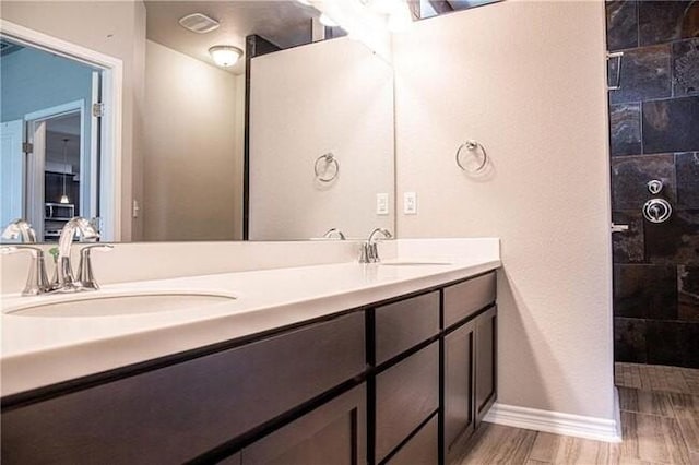 1020 Pasadena St, Portland, TX 78374 - bathroom with double vanity, tiled shower, baseboards, and wood finished floors