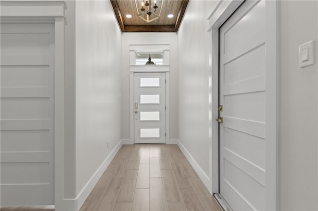 entryway with light wood-type flooring and wooden ceiling