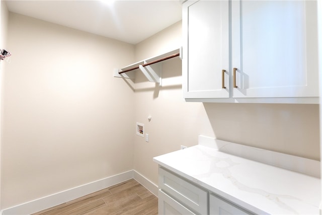 washroom featuring cabinets, washer hookup, and light hardwood / wood-style flooring