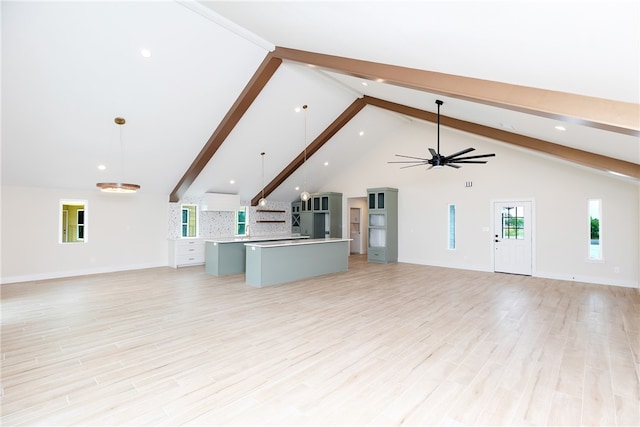 unfurnished living room featuring light wood-type flooring, ceiling fan, and beam ceiling