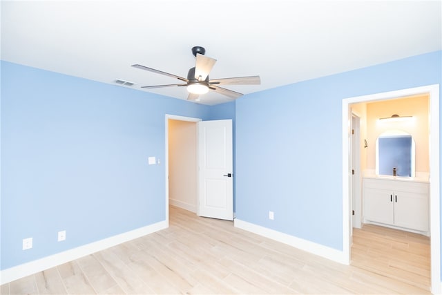 unfurnished bedroom with light wood-type flooring, ceiling fan, and connected bathroom