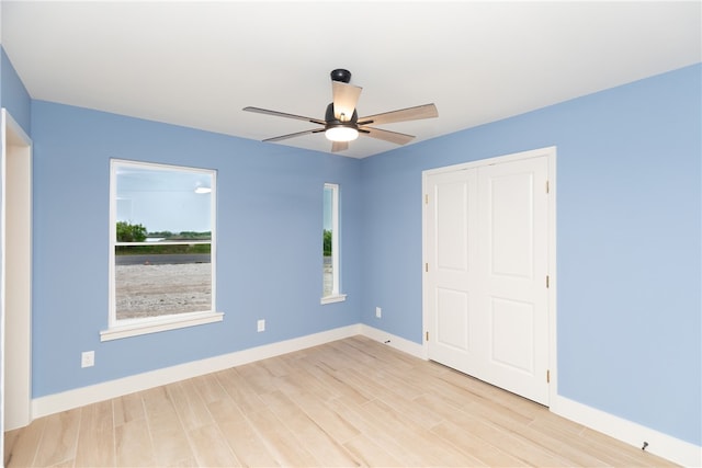 unfurnished bedroom featuring light wood-type flooring, ceiling fan, and a closet