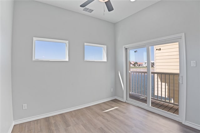 spare room featuring light hardwood / wood-style flooring, ceiling fan, and plenty of natural light