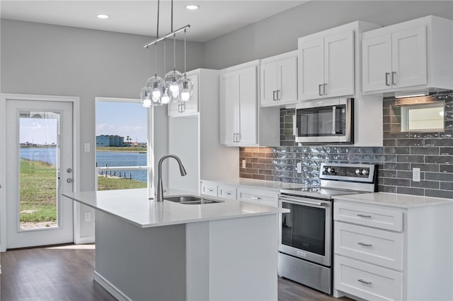 kitchen featuring white cabinetry, a water view, a center island with sink, and stainless steel appliances