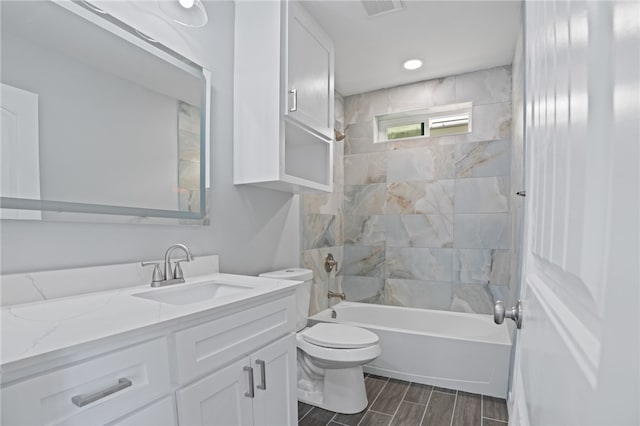 full bathroom with vanity, tiled shower / bath combo, and toilet